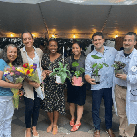 faculty and residents holding plants at end of the year celebration