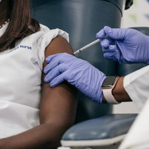A healthcare worker received the first dose of the COVID-19 vaccine in New York