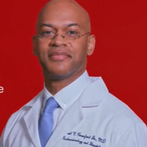 person with white lab coat in front of a red background